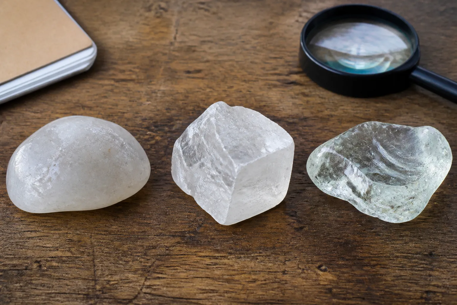 Three pale translucent specimens with similar appearances but different surfaces